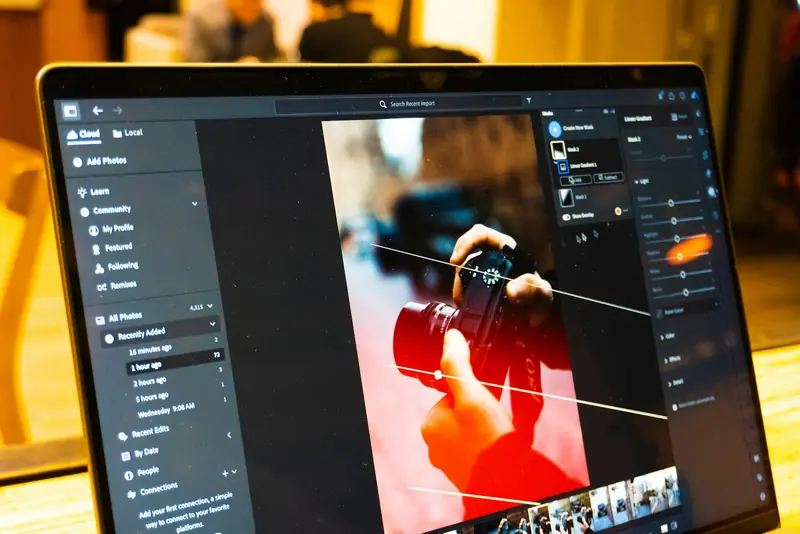A laptop running a photo-editing app with a photo of a red camera open