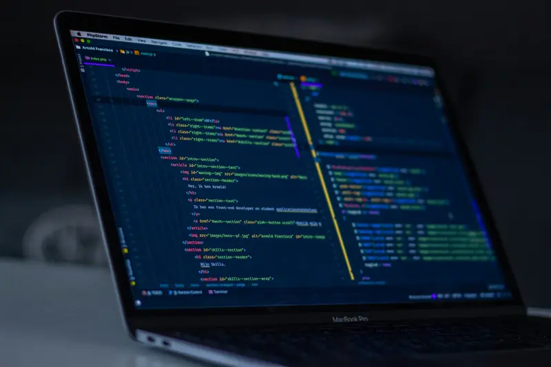 A MacBook Pro showing HTML in a code editor